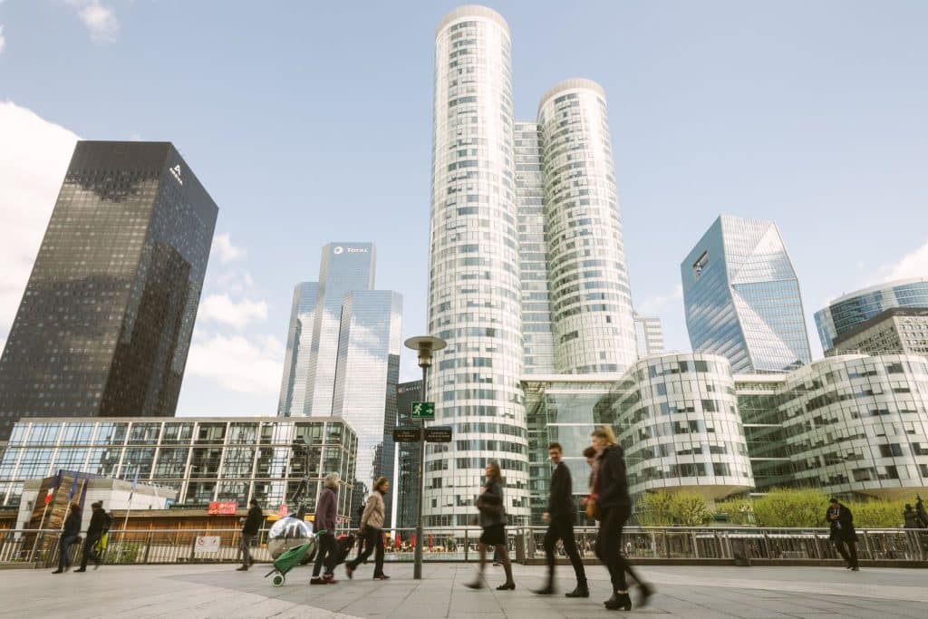 Employees walking through the La Défense business district in Paris — relocating an employee to France