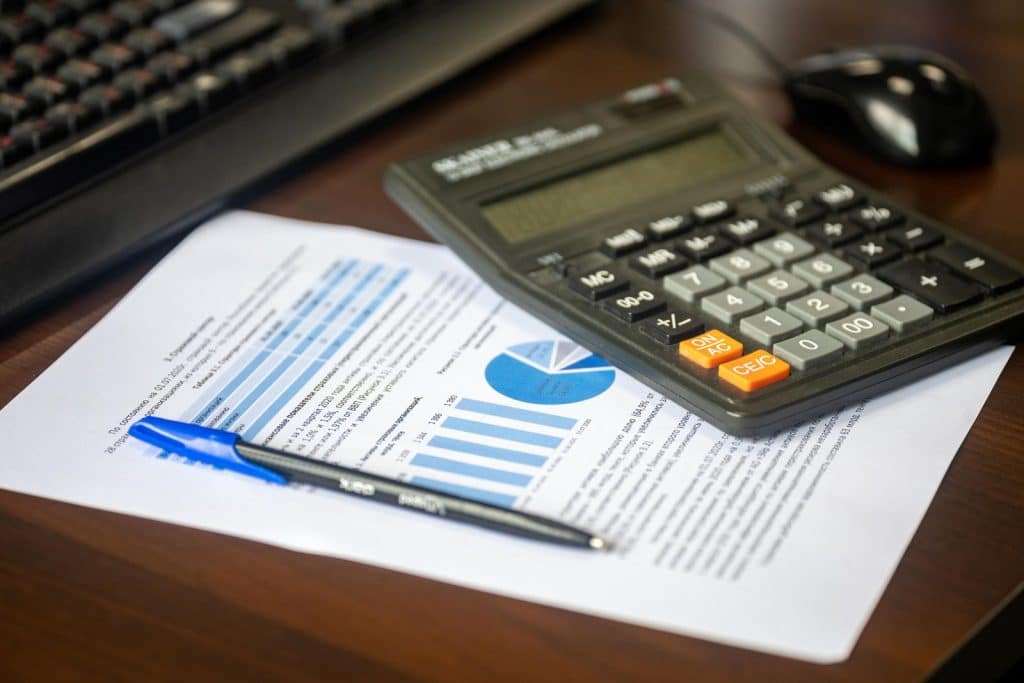 Calculator and financial report on a desk — French payroll withholding for foreign employers