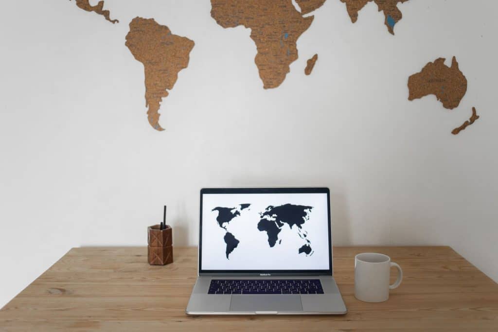 World map on a laptop screen on an office desk — the France–US social security agreement