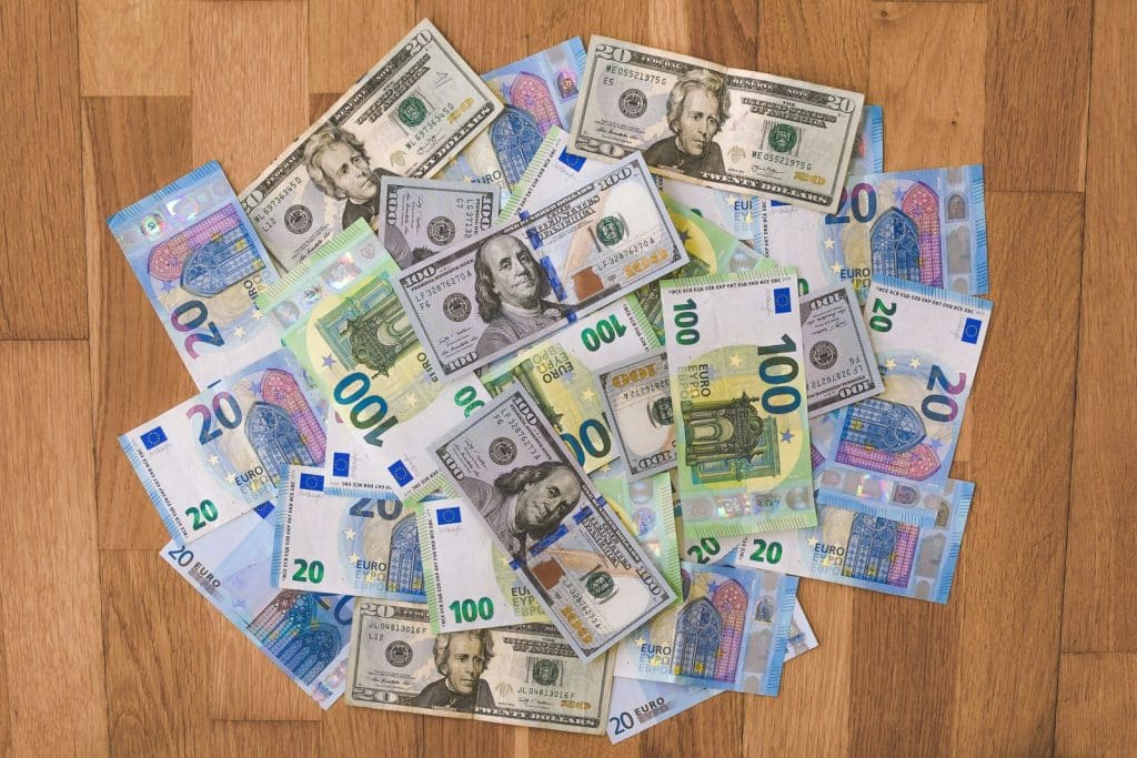 Billets en euros et en dollars côte à côte — réévaluation des devises selon le PCG